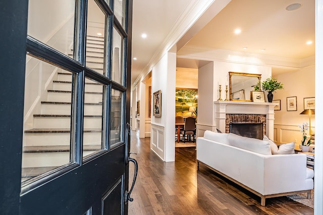 living room featuring ornamental molding, a fireplace, and dark wood-type flooring