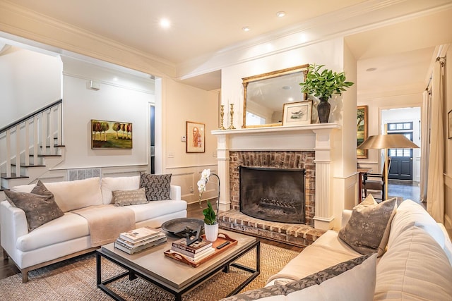 living room with crown molding and a brick fireplace