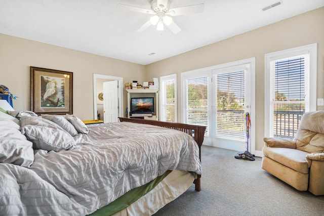 carpeted bedroom featuring ceiling fan, access to exterior, and multiple windows