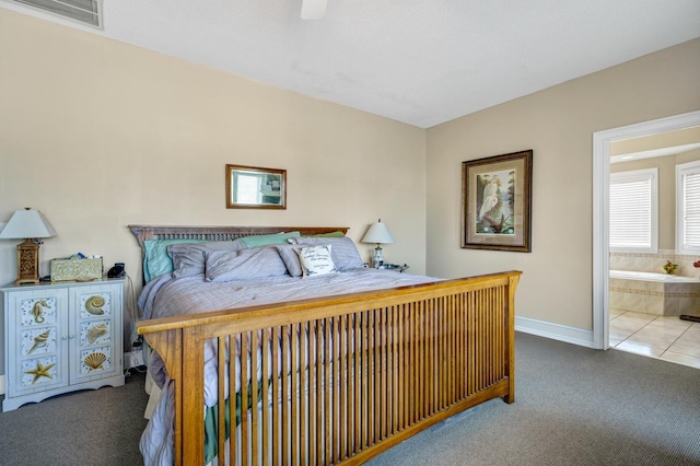 carpeted bedroom with ceiling fan and ensuite bath