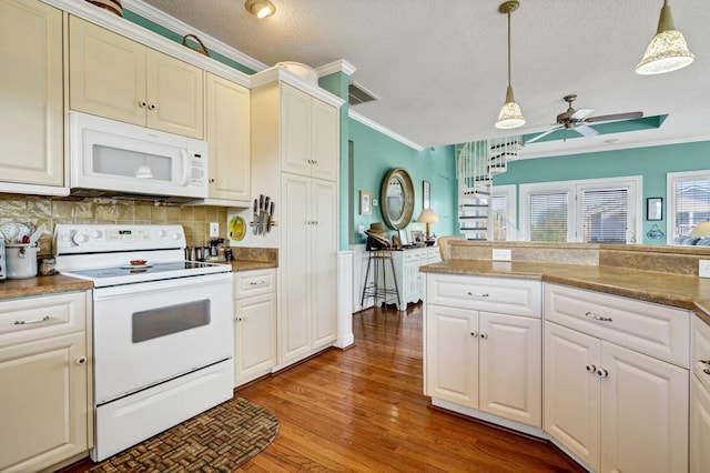 kitchen with ornamental molding, white appliances, a textured ceiling, hardwood / wood-style floors, and hanging light fixtures