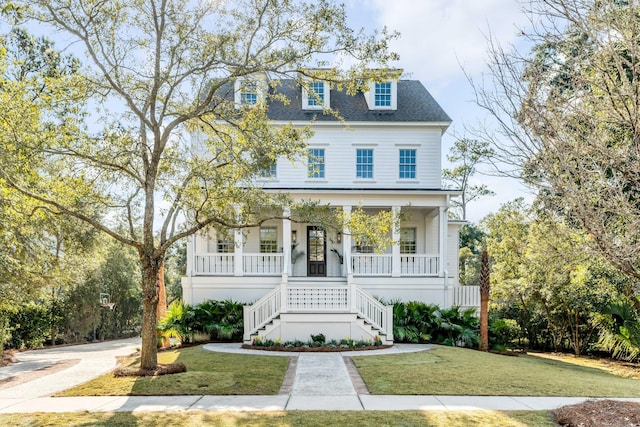 view of front of house featuring covered porch, a shingled roof, stairs, and a front lawn