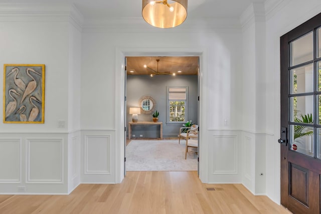 entrance foyer featuring wood-type flooring and ornamental molding