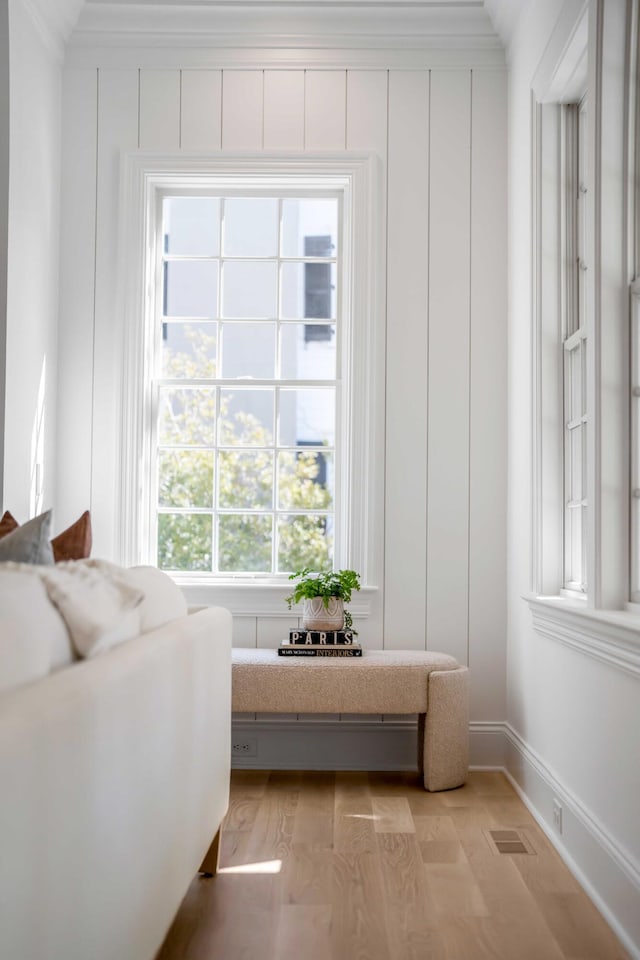 living area featuring ornamental molding and light wood-type flooring