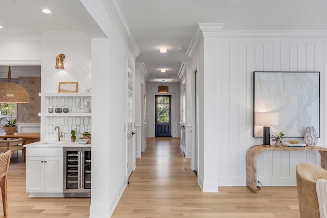 hall featuring wine cooler, crown molding, and light hardwood / wood-style floors