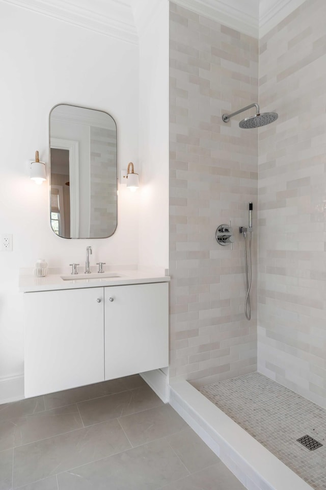 bathroom featuring crown molding, tile patterned floors, vanity, and a tile shower