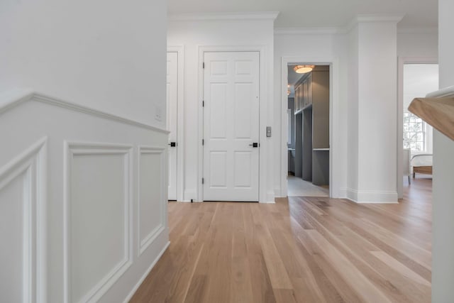 corridor with crown molding and light hardwood / wood-style flooring