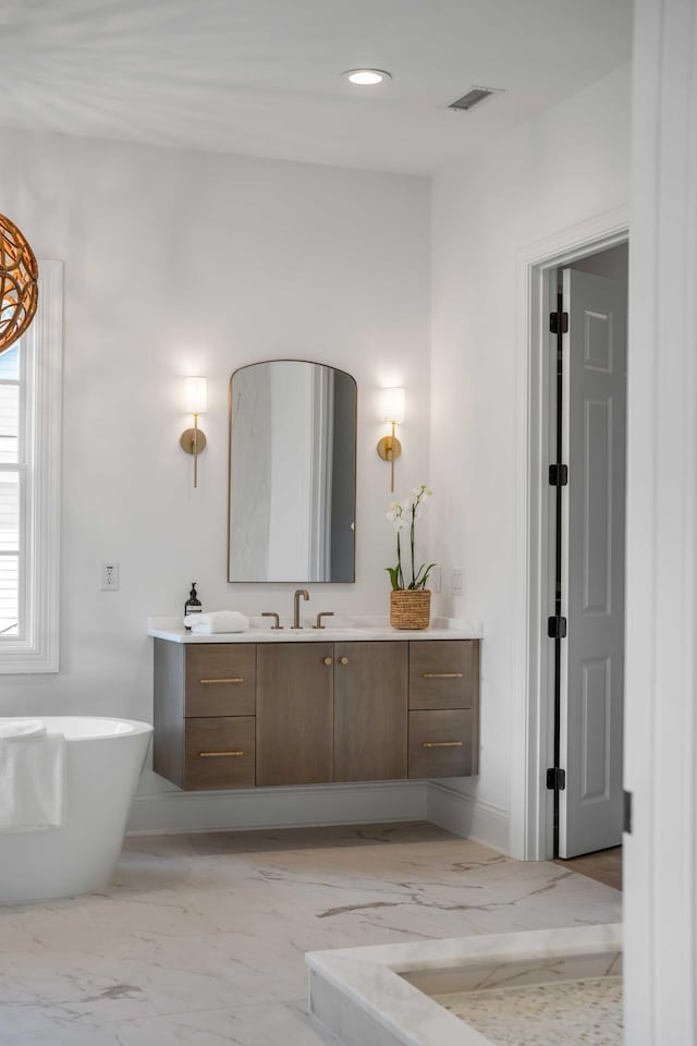 bathroom featuring vanity and a tub to relax in