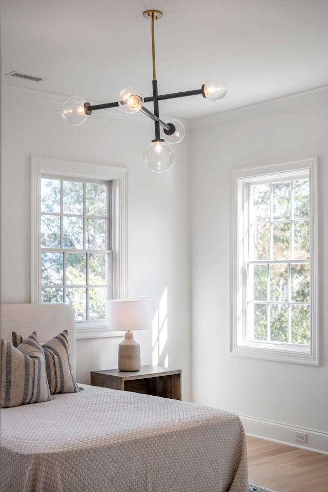 bedroom with crown molding and light wood-type flooring