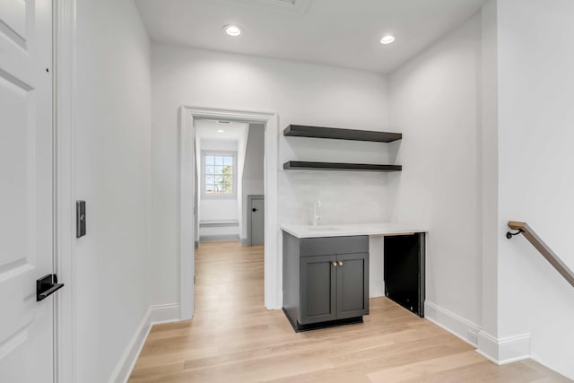 bar with sink and light hardwood / wood-style flooring