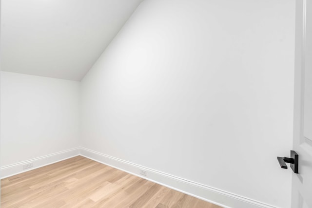 additional living space featuring lofted ceiling and light wood-type flooring