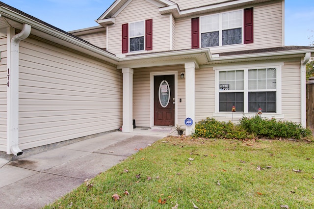 view of exterior entry with a yard