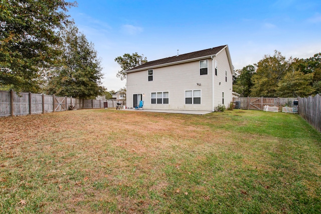 back of property with a patio area and a yard