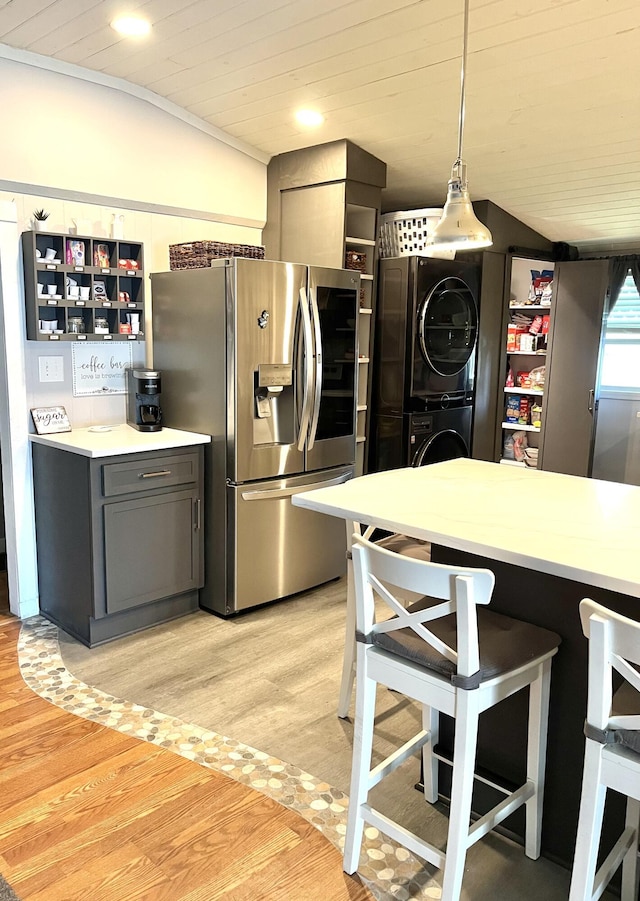 kitchen with stainless steel fridge with ice dispenser, open shelves, a breakfast bar, and light wood-style flooring