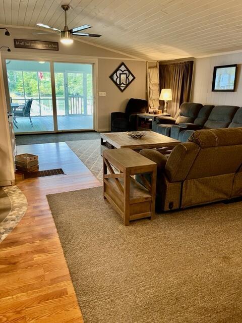 living room with wooden ceiling, wood finished floors, a ceiling fan, and crown molding