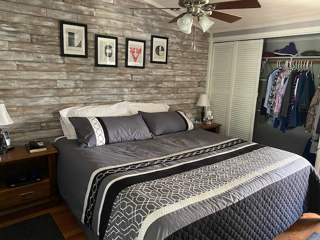 bedroom featuring wood finished floors, a closet, wood walls, and a ceiling fan