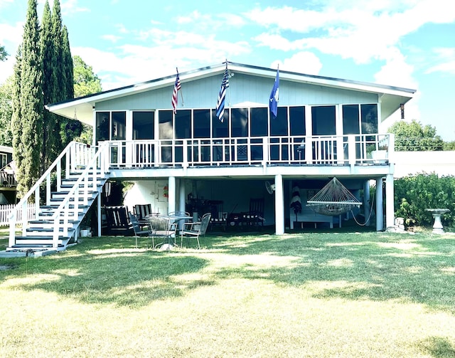 back of house featuring a yard, a sunroom, and stairs