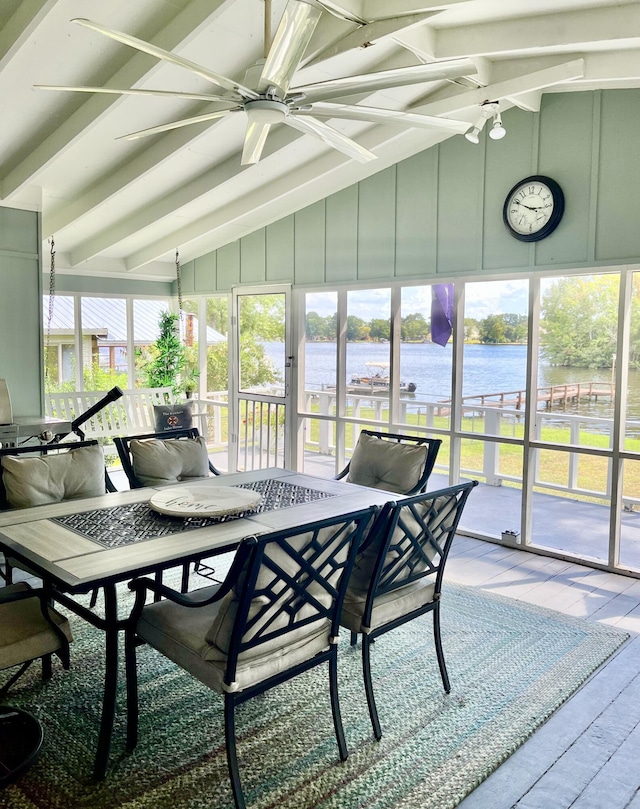 sunroom / solarium featuring beamed ceiling, a water view, and a ceiling fan