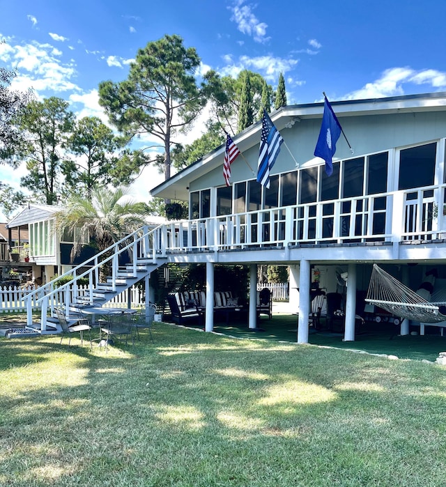 rear view of property with a yard and stairs