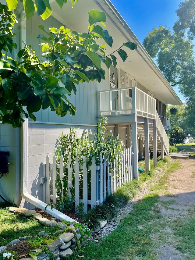 view of side of home with stairs and concrete block siding