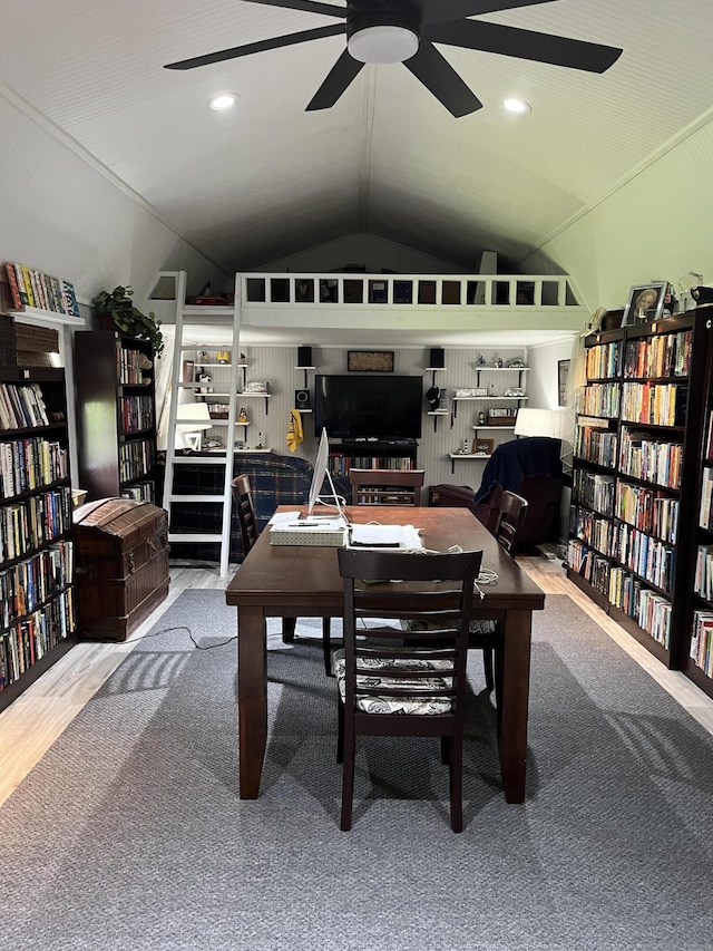 office space with wall of books, vaulted ceiling, and a ceiling fan