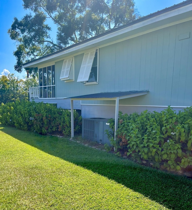 view of home's exterior with a lawn and central air condition unit