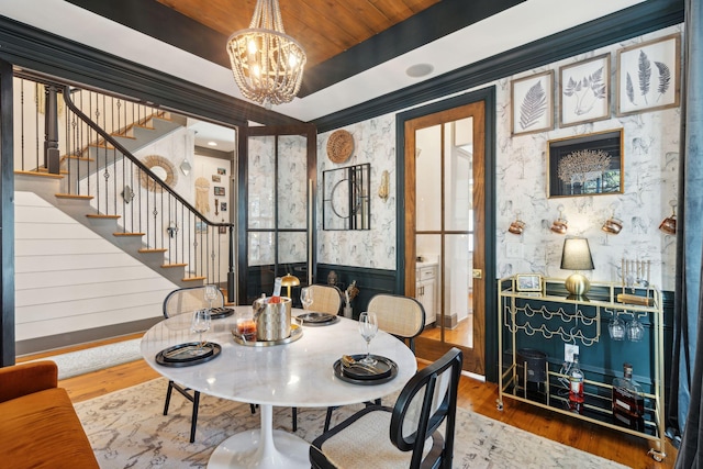 dining area featuring wood-type flooring, a chandelier, a tray ceiling, and wood ceiling