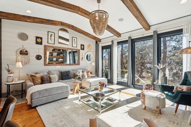 living room featuring wood walls, vaulted ceiling with beams, and light hardwood / wood-style flooring