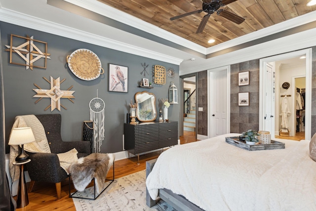 bedroom featuring ensuite bathroom, wood ceiling, ornamental molding, ceiling fan, and wood-type flooring