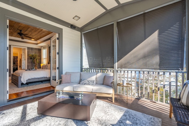 sunroom / solarium featuring lofted ceiling, ceiling fan, and wood ceiling