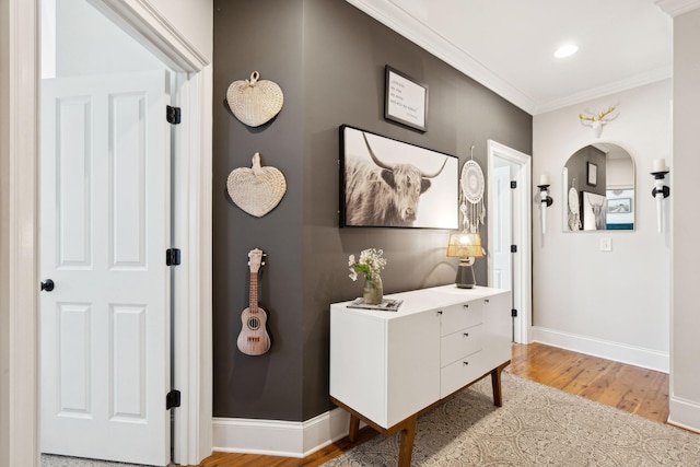 hall with ornamental molding and hardwood / wood-style floors