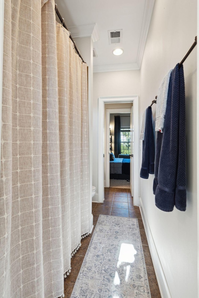 interior space with ornamental molding and dark tile patterned floors