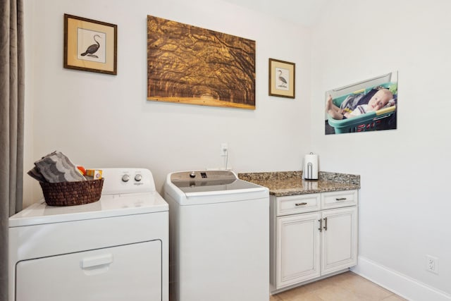 laundry area featuring washer and dryer, cabinets, and light tile patterned flooring