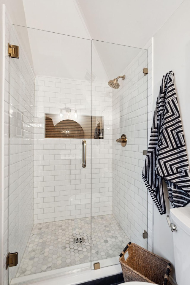 bathroom with toilet and a shower with door