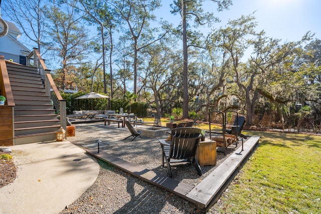 view of yard featuring an outdoor living space with a fire pit and a patio