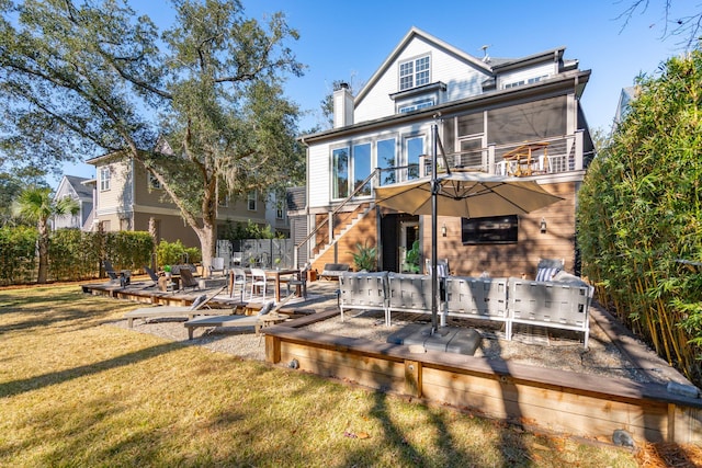 rear view of house with a deck, a yard, and a sunroom