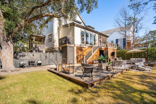 rear view of property with a deck and a lawn