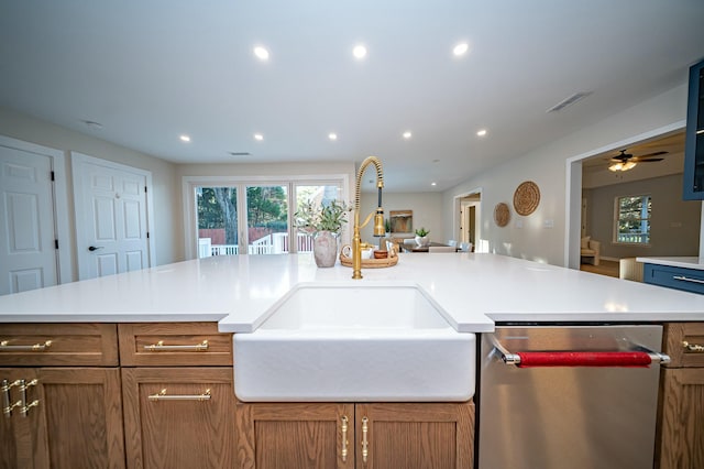 kitchen with brown cabinets, light countertops, a sink, and dishwasher