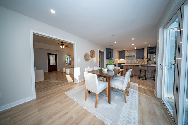 dining area featuring light wood-style floors, baseboards, and recessed lighting