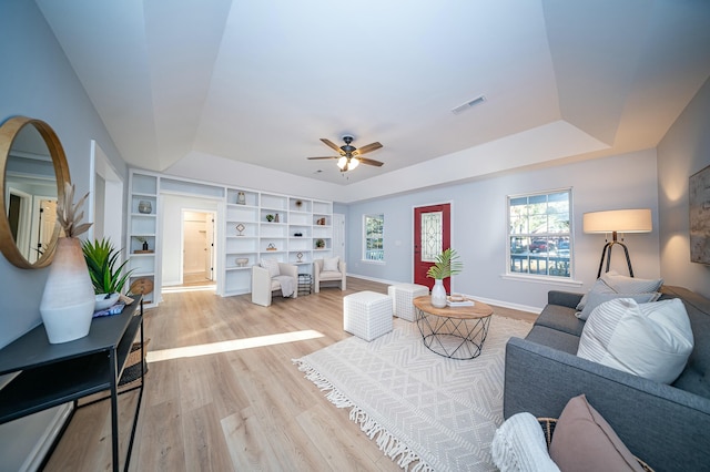 living room featuring a healthy amount of sunlight, visible vents, and a tray ceiling