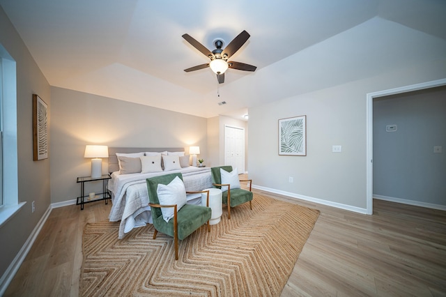 bedroom featuring light wood-style flooring, baseboards, ceiling fan, and a closet