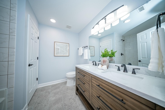 full bath featuring visible vents, double vanity, a sink, and toilet