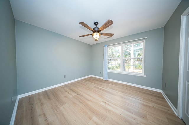 spare room with light wood finished floors, ceiling fan, and baseboards