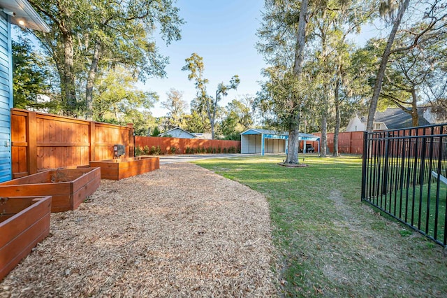 view of yard with an outbuilding, a storage shed, a fenced backyard, and a garden