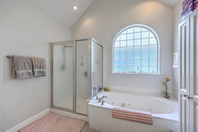 full bath with vaulted ceiling, a tub with jets, and a stall shower
