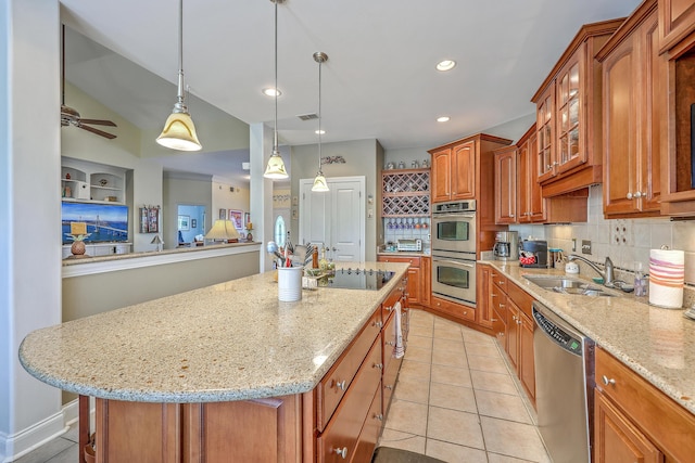 kitchen featuring a sink, light stone counters, a center island, and stainless steel appliances