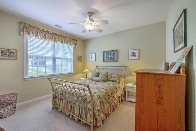 bedroom featuring visible vents, baseboards, ceiling fan, and light colored carpet
