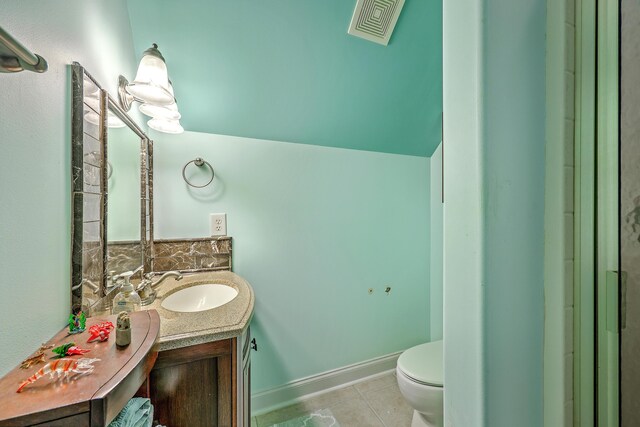 half bathroom featuring vanity, toilet, tile patterned floors, baseboards, and visible vents