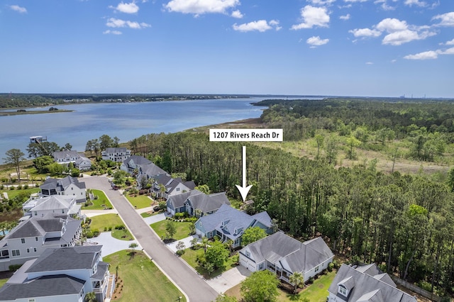 aerial view with a residential view, a view of trees, and a water view