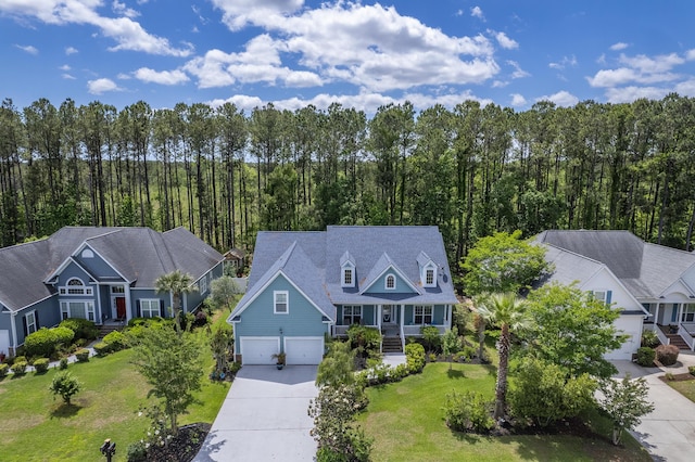 view of front of house with a porch, an attached garage, driveway, and a front yard